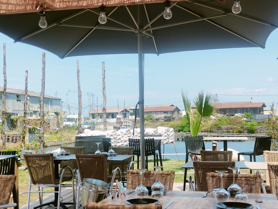 Terrasse de la cabane Les Tuiles Blanches, vue sur le port ostréicole